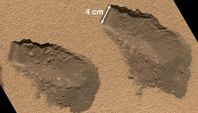 Toma del rover Curiosity recogiendo muestras en Marte