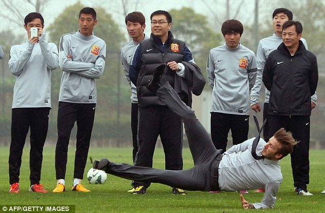 (Foto: Daily Mail) David Beckham pierde el equilibrio y cae ante jóvenes futbolistas Chinos